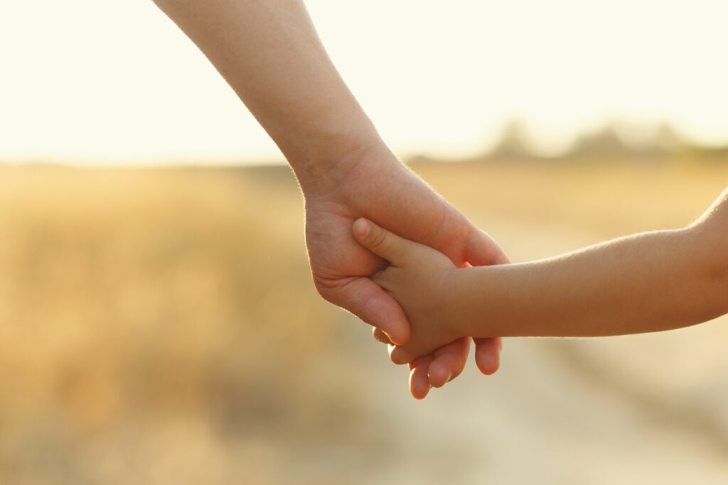 Erwachsenenhand hält Kinderhand